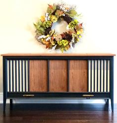 an old dresser with a wreath on top and the words vintage refined above it