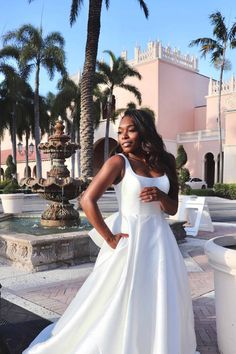 a woman in a white dress posing for the camera