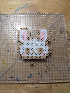 a piece of art made out of perler beads on top of a wooden table