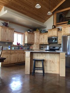 a large kitchen with wooden cabinets and an island in the middle of the room is shown