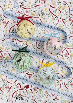 four christmas ornaments on a table with ribbons