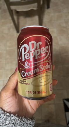 a person holding up a can of ice cream soda