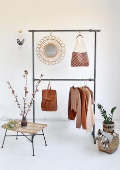 an iron rack with several purses and handbags hanging on it