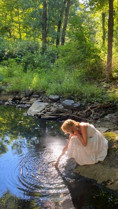 a woman kneeling down in the water