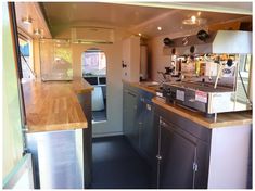 the inside of a small kitchen with stainless steel appliances and wood counter tops, along with an open door leading to another room