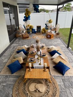 a table set up for a party with blue and gold decorations