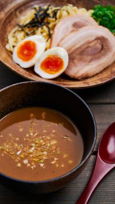 a bowl of soup with hard boiled eggs on the side and other foods in it