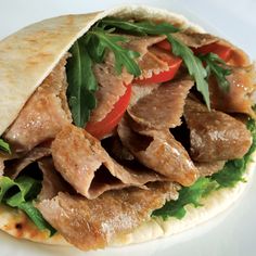 a pita sandwich with meat, lettuce and tomatoes