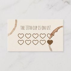 the 10th cup is on us card with hearts and an arrow in brown, beige and white