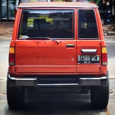 an orange suv is parked on the side of the road