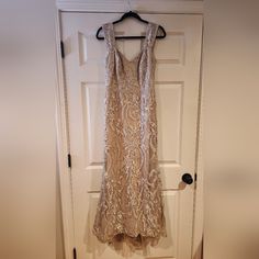 a dress hanging on a hanger in front of a door