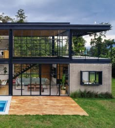 a modern house with a pool in the yard and large glass windows on the side