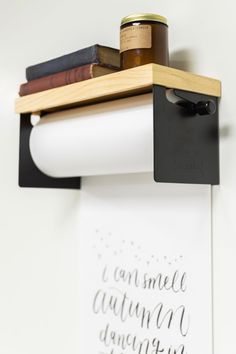 a wall mounted shelf with some books and a jar on it's end, next to a sign that says i can smell autumn