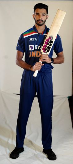 a man holding a cricket bat in his hand and posing for the camera with it's leg up