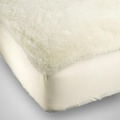 an image of a bed with white fur on the top and bottom part of it