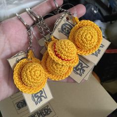 two yellow crocheted hamburgers are being held by a person's hand