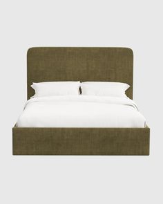 a bed with white sheets and pillows on top of it's headboard, in front of a gray background