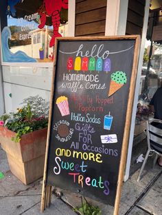 a chalkboard sign with some writing on it in front of a store that sells sweet treats