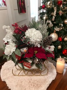 a sleigh filled with christmas decorations next to a christmas tree