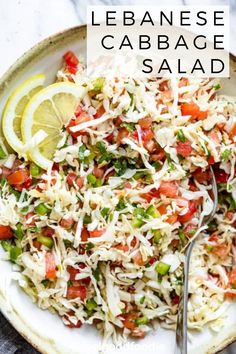 a white plate topped with cole slaw and lime wedges next to a fork