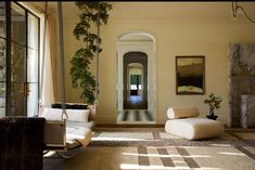 a living room filled with furniture and a fire place next to a window covered in plants