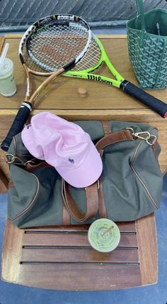 a tennis racket and bag sitting on top of a table next to other items