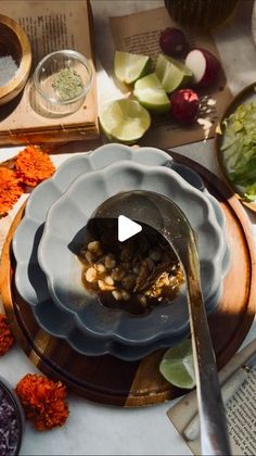 a table topped with plates and bowls filled with food next to utensils on top of each other