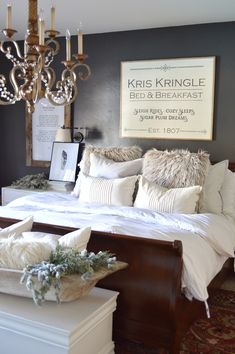 a bedroom with a bed, chandelier and pictures on the wall above it