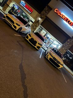 three cars parked in front of a store at night