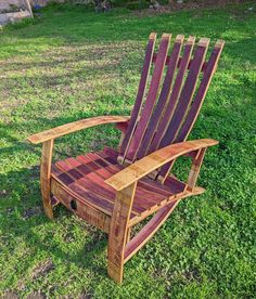 a wooden chair sitting on top of a lush green field