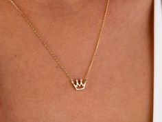 "The 14K Gold Crown Necklace is a delicate and dainty piece of jewelry that is perfect for any princess in your life. It features a tiny solid gold crown pendant that is delicate and feminine, making it a perfect choice for those who prefer subtle and understated jewelry. This necklace is made from 14K gold, which is a high-quality and valuable metal that is resistant to tarnish and wear. It is the perfect gift for any special occasion, whether it be for Christmas, Father's Day, Mother's Day, Va 14k Gold Crown Design Jewelry As A Gift, 14k Gold Jewelry With Crown Design For Gift, Dainty Jewelry With Crown Design For Gift, Dainty Jewelry With Crown Design As Gift, Crown Jewellery, Understated Jewelry, Crown Pendant Necklace, Mini Crown, Crown Pendant