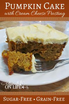 a slice of pumpkin cake with cream cheese frosting on a white plate next to a fork