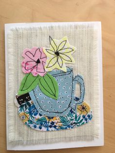 an embroidered teacup with flowers on it