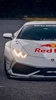 a white sports car with red bull logo on it