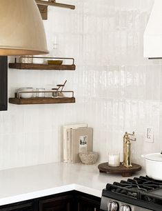 a stove top oven sitting inside of a kitchen next to a wall mounted range hood