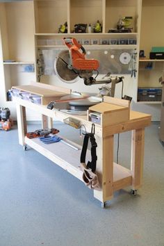 a workbench with tools on it and a sawhorse in the background,