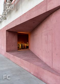 an empty parking garage with clothes hanging in it's door and stairs leading up to the second floor