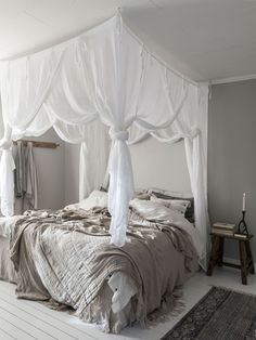 a bed with white drapes on top of it