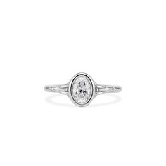 a white gold ring with an oval shaped diamond in the center, on a white background