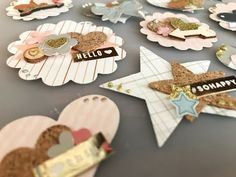 there are many different types of paper decorations on the table with name tags and magnets