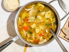 a pot filled with soup next to some bread