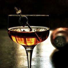 a glass filled with liquid sitting on top of a table