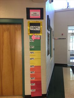 a school hallway with a bulletin board displaying the percentage of students'attendance in each class