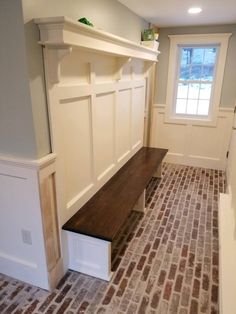 an empty room with brick flooring and built in shelves on either side of the wall