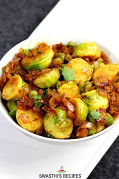 a white bowl filled with brussel sprouts on top of a table