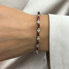 This Beautifully Crafted Tennis Bracelet Features Pear Shaped Rubies With Baguette And Round Cut Diamonds In Prong And Channel Setting. Crafted In 14k White Gold. Total Diamond Weight: 1.58 Carats. Diamond Quality: G-H Color And Si Clarity. Total Ruby Weight: 4.68 Carats. Length: 7 Inches. Width: 3.8mm. Total Weight: 9.38 Grams. Bracelet Closes Securely With A Box Clasp. This Tennis Bracelet Is A Timeless Piece That Holds A Place In The Collection Of Every Jewelry Lover. Comes With A Presentable Ruby Tennis Bracelet, Elegant Red Tennis Bracelet For Anniversary, Red Fine Jewelry Tennis Bracelet For Wedding, Red Tennis Bracelet For Wedding, Red Fine Jewelry Tennis Bracelet For Formal Occasions, Formal Red Diamond Jubilee Bracelet, Red Tennis Bracelet For Formal Occasions, Classic Red Diamond Bracelet For Formal Occasions, Red Tennis Bracelet With 17 Jewels For Wedding