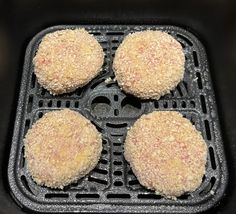 four fried meat patties sitting on top of a frying pan in an air fryer