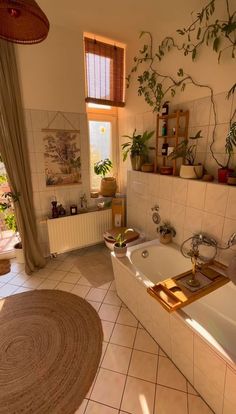 a bathroom with a tub, sink and plants on the window sill in it