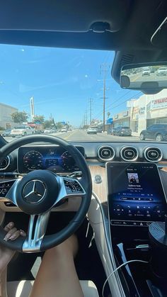 the interior of a car with dashboard, steering wheel and electronic devices on display at an intersection