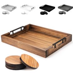 a wooden tray with two black plates and one white plate next to it, all in different shapes and sizes